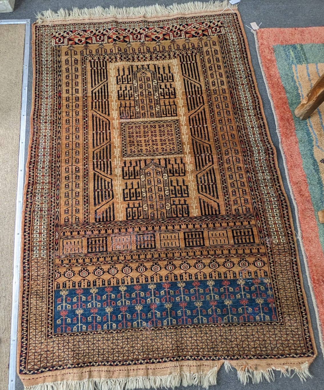 A Caucasian beige ground rug with central field of stylised motifs, 204 x 130cm